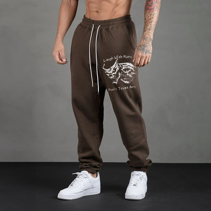 LAUGH WITH MANY, DON’T TRUST ANY SKULLS GRAPHIC PRINT JOGGERS