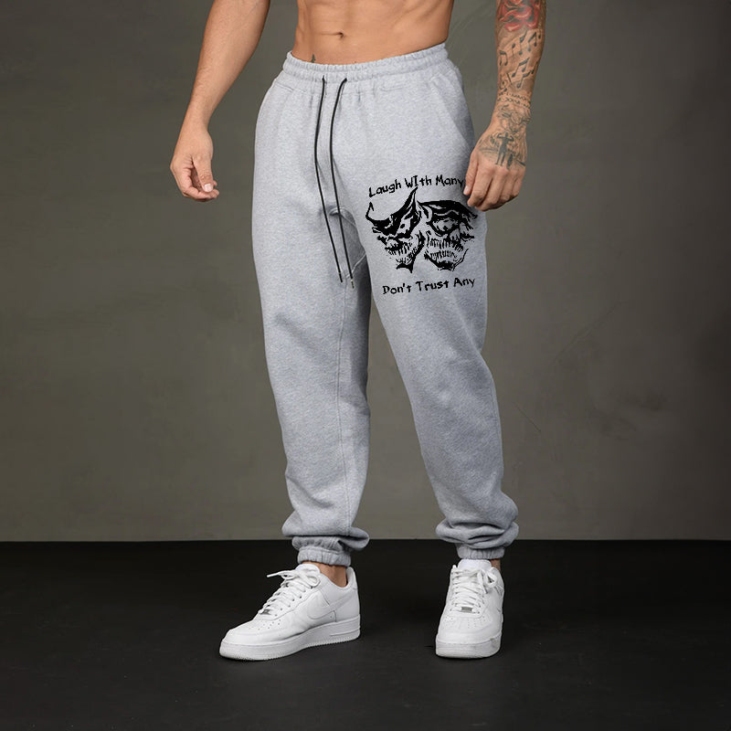 LAUGH WITH MANY, DON’T TRUST ANY SKULLS GRAPHIC PRINT JOGGERS